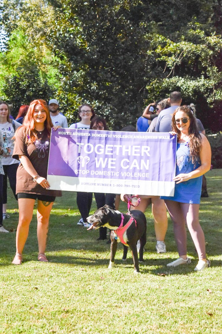 two women holding a sign