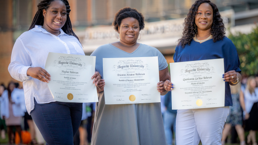 3 women holding diplomas