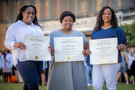3 women holding diplomas
