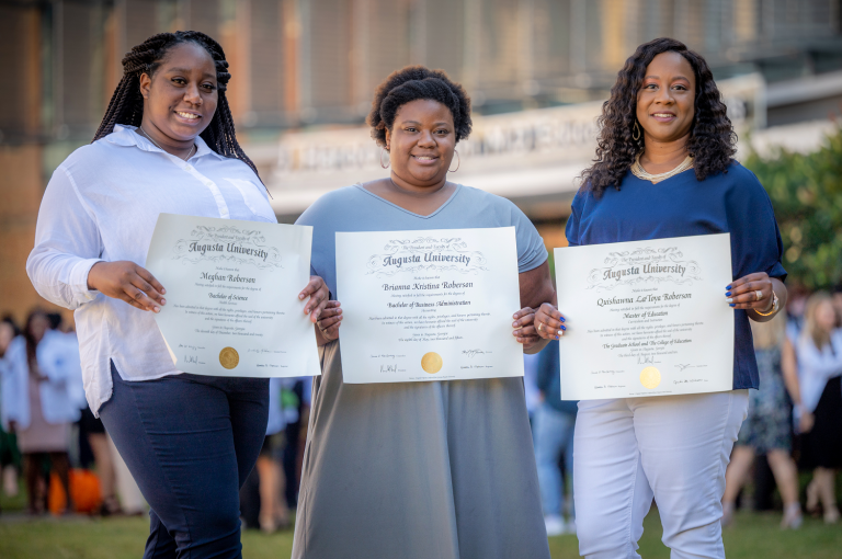 3 women holding diplomas