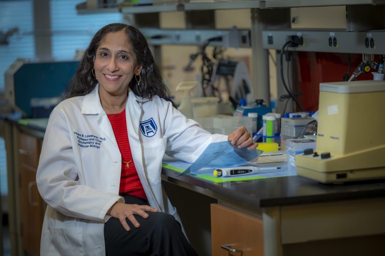 Woman in white coat smiling at camera