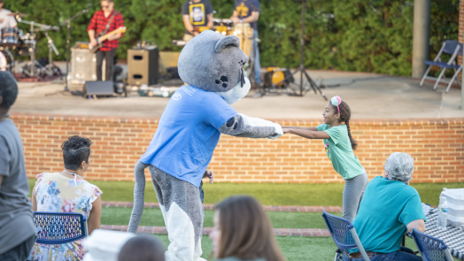 young girl playing with mascot