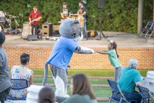young girl playing with mascot