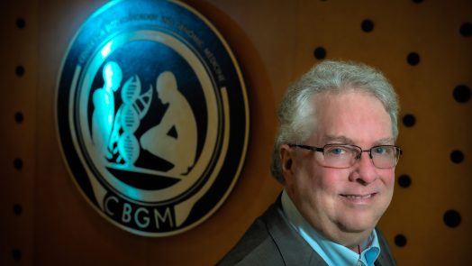 Man with glasses smiles at camera