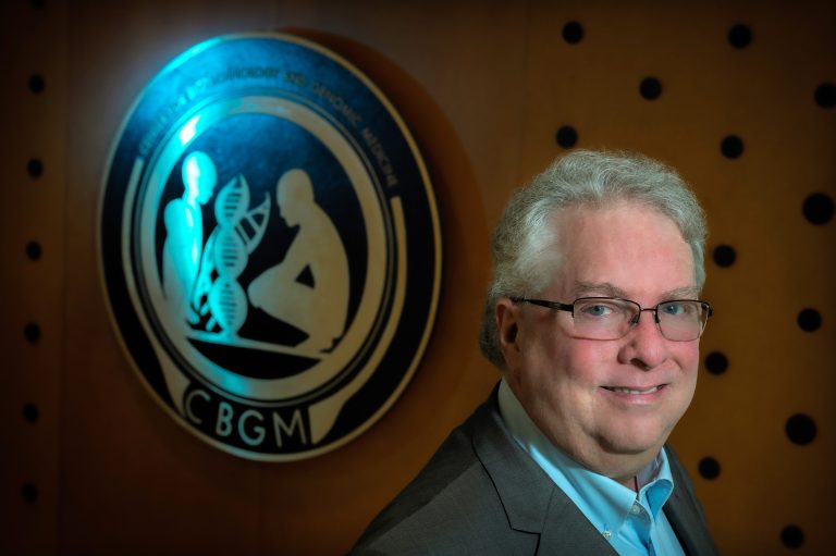 Man with glasses smiles at camera