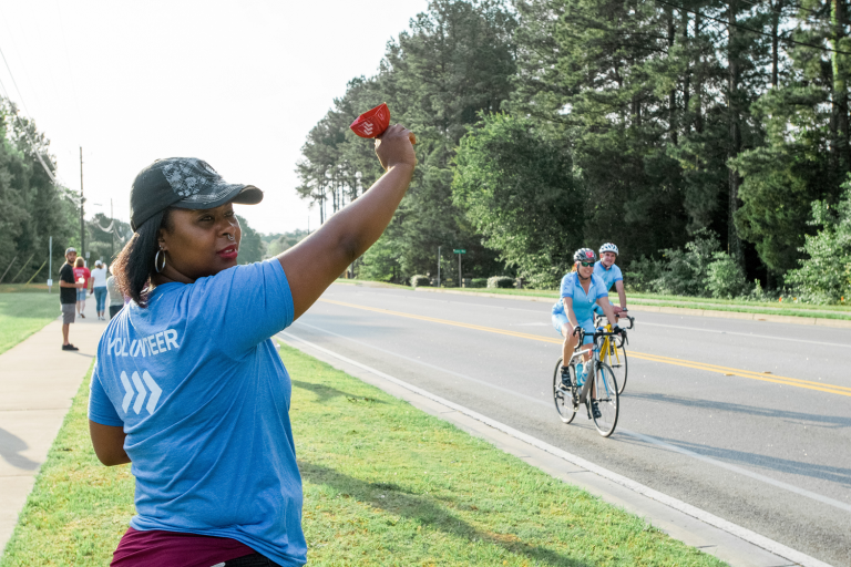 woman volunteer cheering on bikers