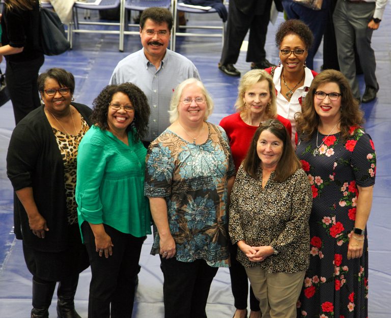 a group of people standing and smiling