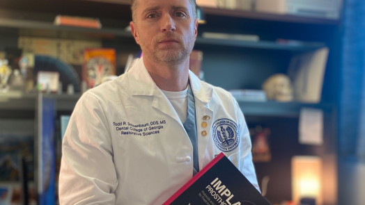 man in white coat holding textbook