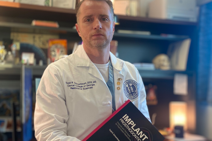 man in white coat holding textbook
