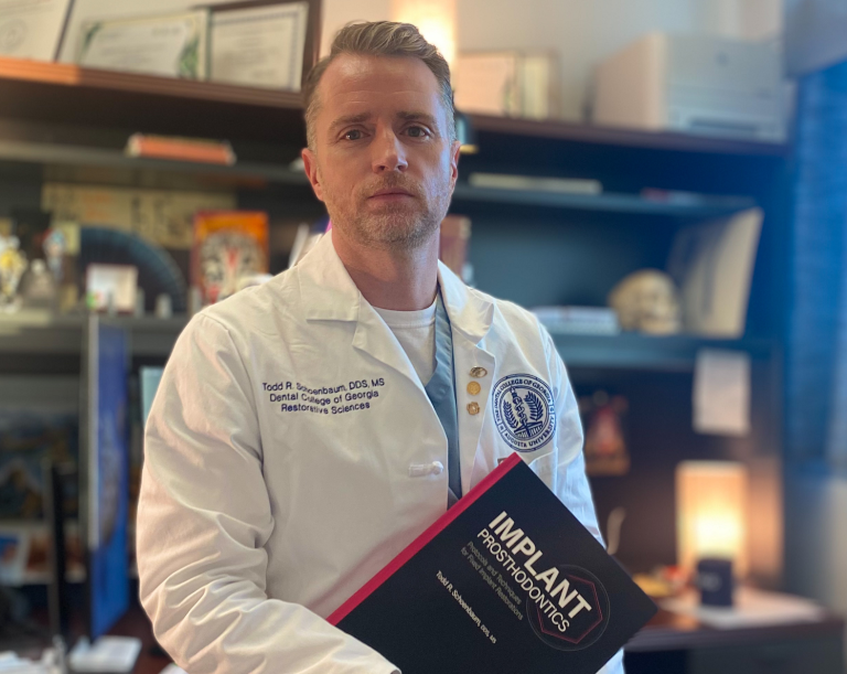 man in white coat holding textbook