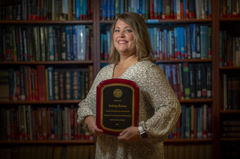 woman holding award plaque