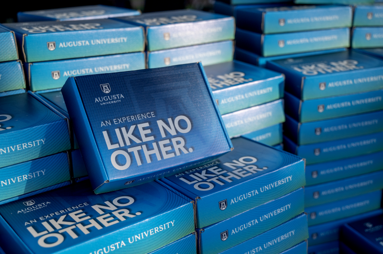 small blue cardboard box that says "An Experience Like No Other" on the front
