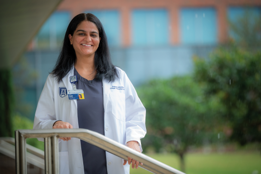 woman in white coat standing outside, smiling