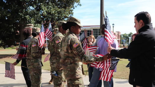 a woman in uniform handing a man a flag