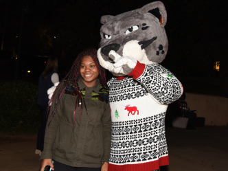 woman standing beside jaguar mascot