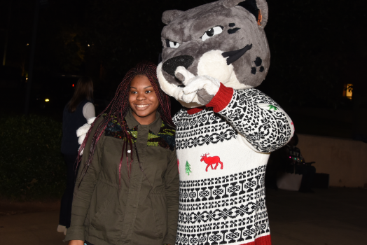 woman standing beside jaguar mascot
