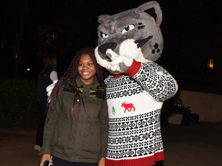 woman standing beside jaguar mascot