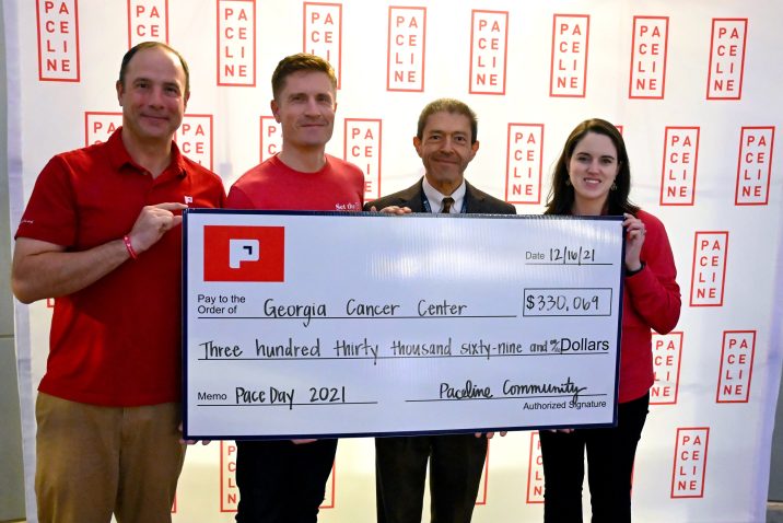 People standing hold a big check