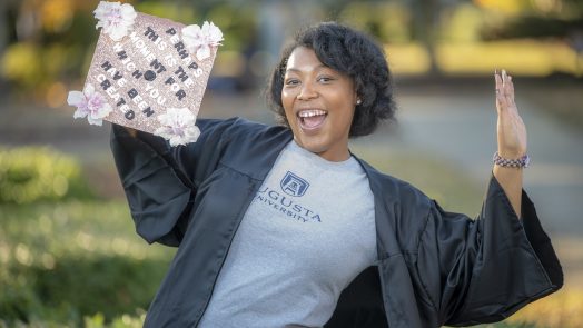 woman smiling with cap and gown