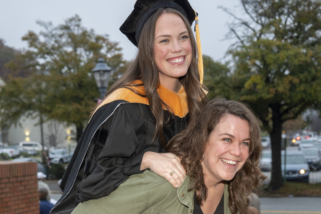 graduate smiling beside woman