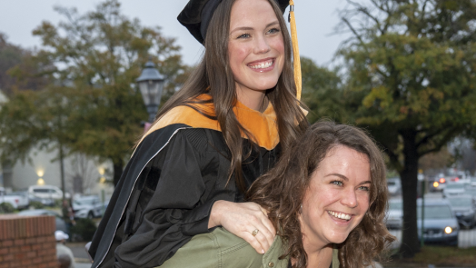 graduate smiling beside woman