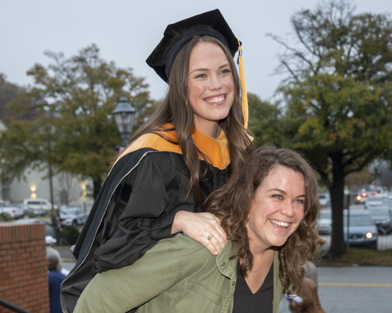 graduate smiling beside woman