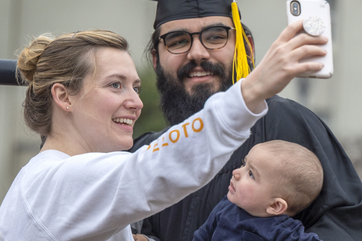 woman taking selfie with graduate and baby