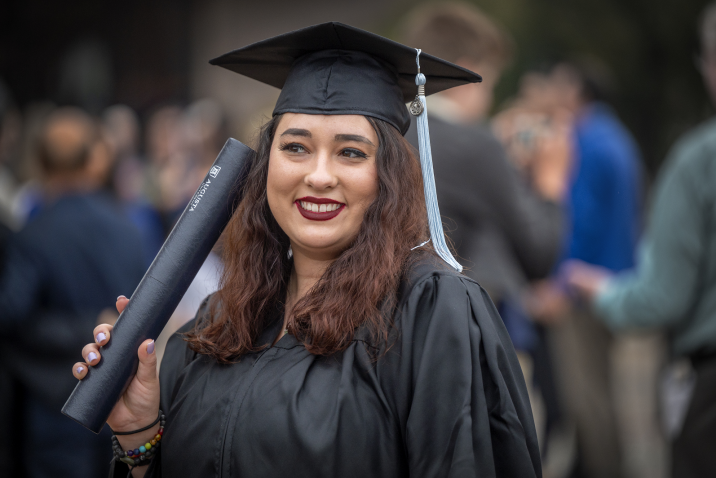 woman wearing cap and gown holding degree