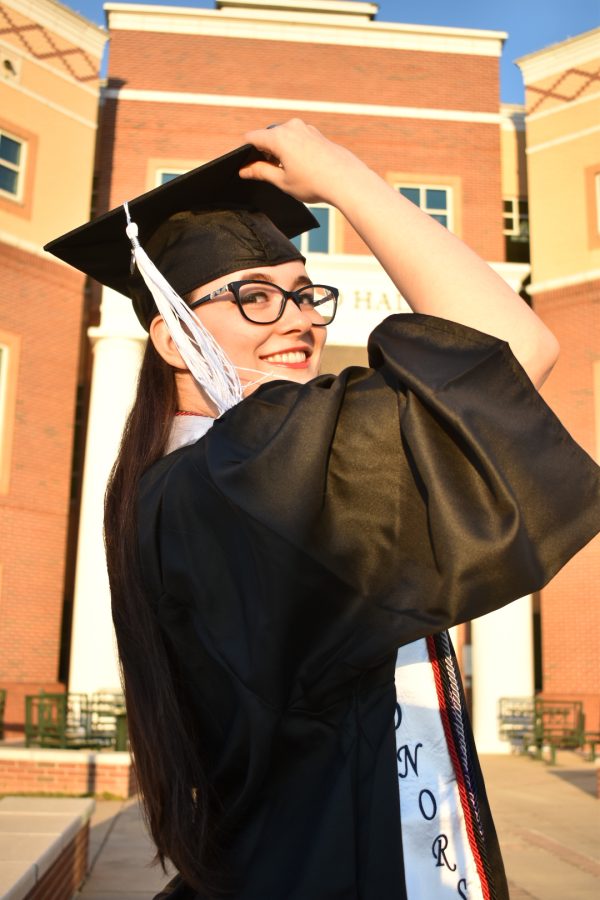 woman smiling wearing cap and gown