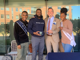 the Augusta University provost standing with 3 students