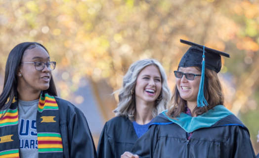women walking in caps and gowns