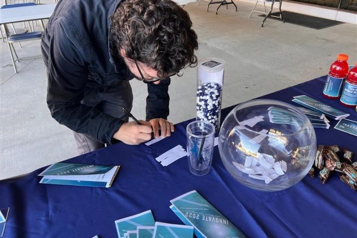 student filling out a form at a tabling event