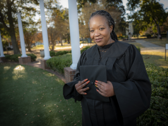 woman standing in cap and gown