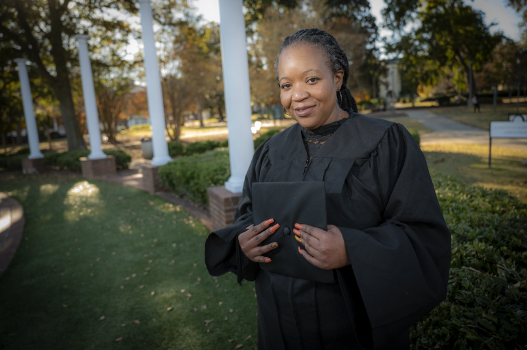 woman standing in cap and gown
