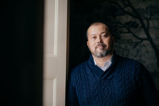man in blue sweater smiling