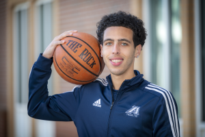 man in blue jacket holding basketball