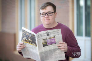 man in glasses holding newspaper