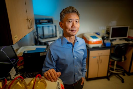 Man in blue shirt stands in lab