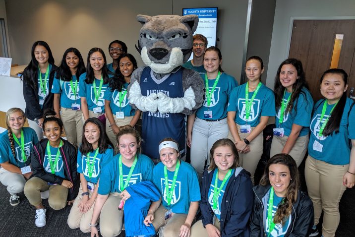 students standing with mascot