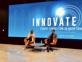 a woman interviewing a man in front of a screen that says "INNOVATE"
