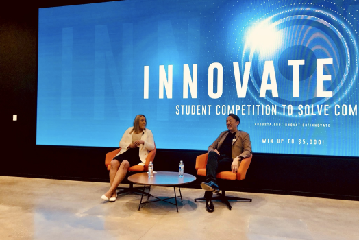 a woman interviewing a man in front of a screen that says "INNOVATE"