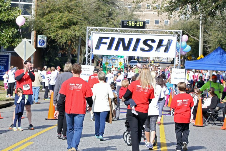 Men, women, and kids walking towards a finish line
