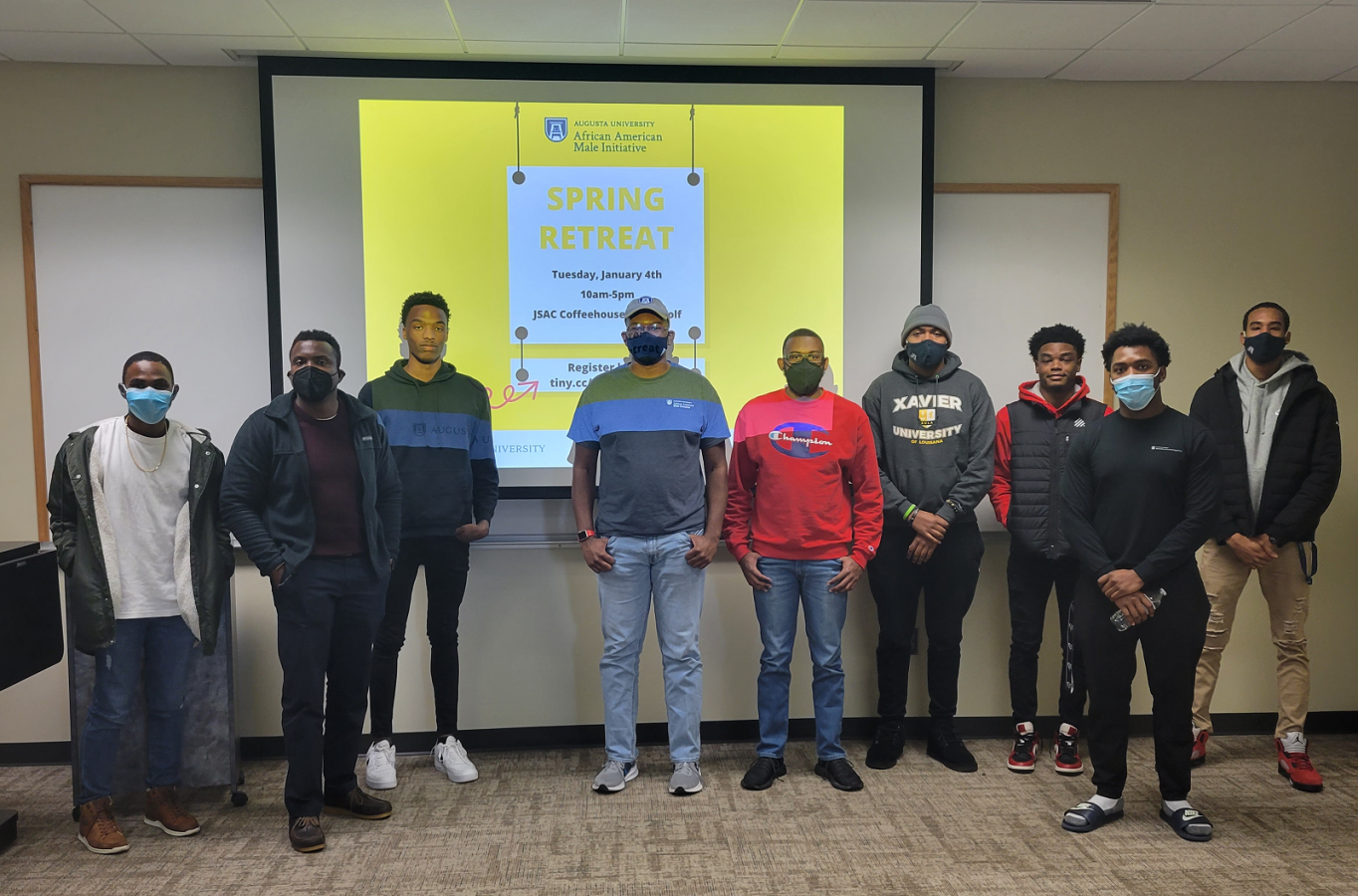 a group of men in front of a presentation