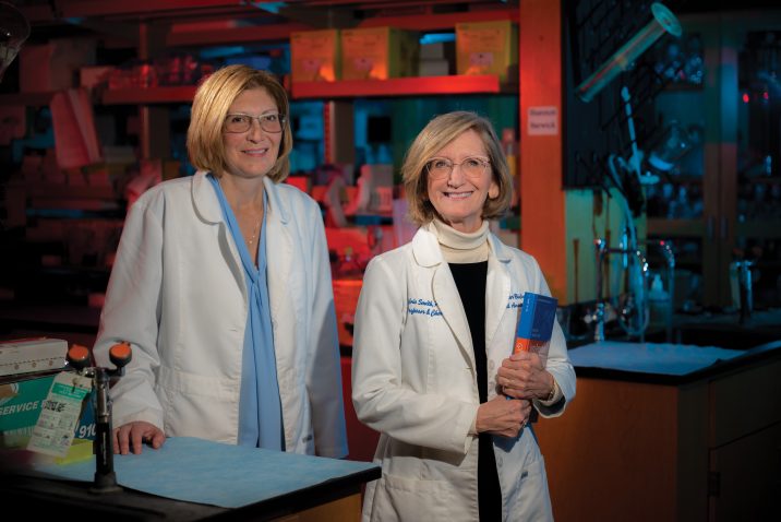 Two women in lab coats standing