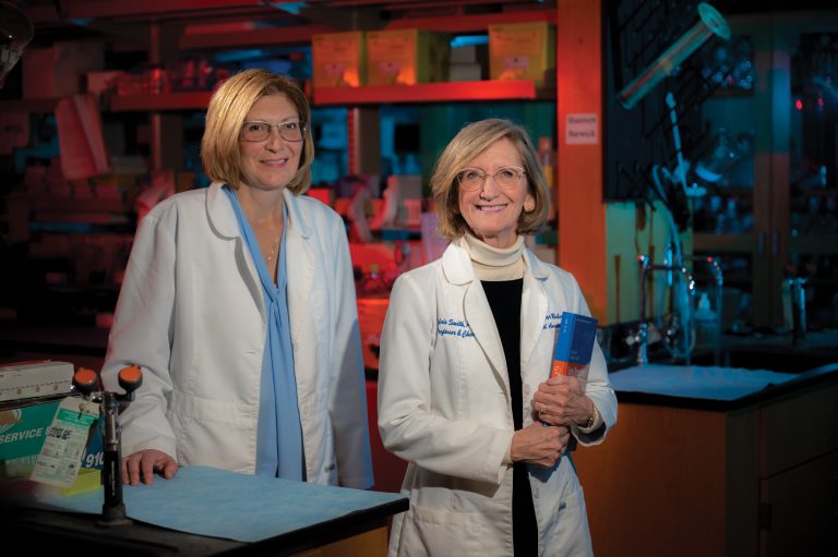 Two women in lab coats standing