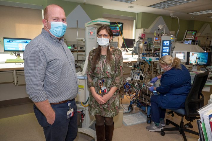 Man and woman in masks stand in NICU