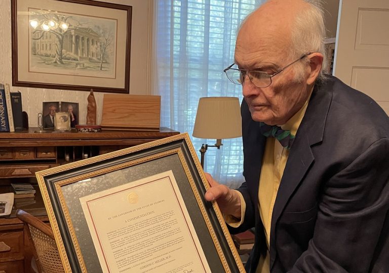 Man holds framed document