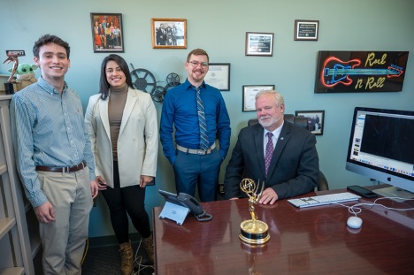 4 people in an office, smiling