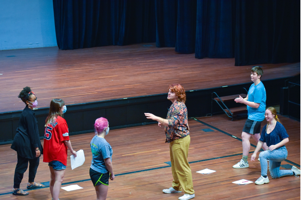 man instructing dancers on stage