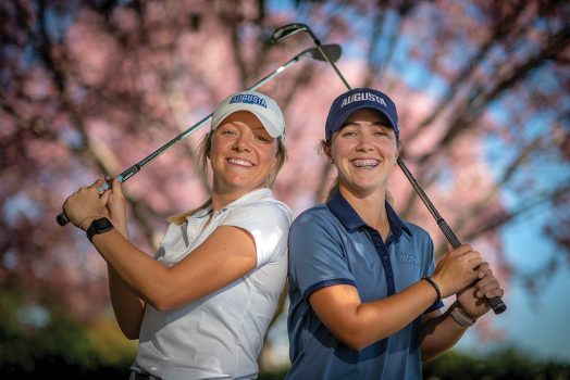 Two women holding golf clubs